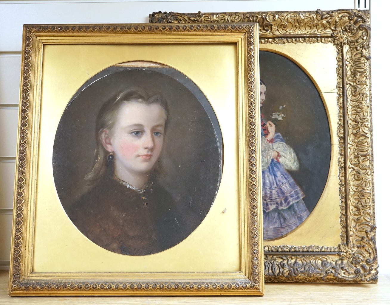 19th century, Naïve school, oval oil on board, three quarter length portrait of a lady, gilt framed, together with a similar portrait of a girl wearing garnet earrings, largest 34 x 24cm
